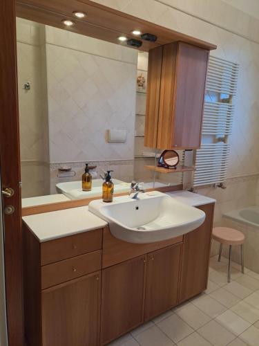 Un baño con lavabo y un espejo grande. en 2 Giugno House, en Bari