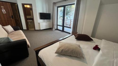 a hotel room with a bed and a couch at Lac Colibita in Colibiţa