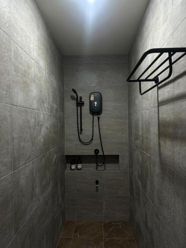 a bathroom with a shower with a light on the wall at WANGTA Hostel in Baan Tai