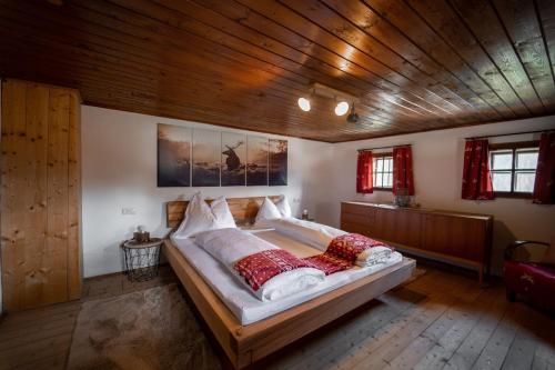 a large bed in a room with a wooden ceiling at Artlieb Hütte in Bischofshofen