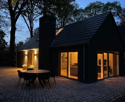 a black house with a table and chairs at De Eekhoorn in Ugchelen