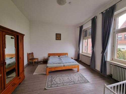 a bedroom with a bed and two windows at Das alte Pastorat in Kevelaer