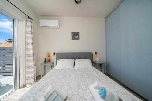 a bedroom with a bed and a large window at Fiora Villas in Trapezaki