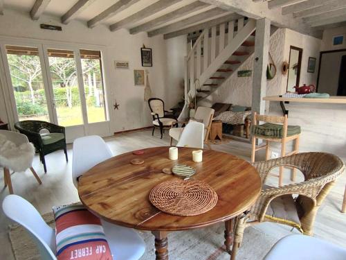 un salon avec une table et des chaises en bois dans l'établissement Villa landaise avec studio indépendant, proche bassin, commerces et plages - 8 pers., jardin, WiFi - FR-1-736-29, à Lège-Cap-Ferret