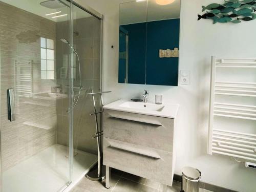 une salle de bain blanche avec un lavabo et une douche dans l'établissement Maison calme avec jardin et Wifi, proche plages Côte de Granit Rose - FR-1-542-64, à Perros-Guirec