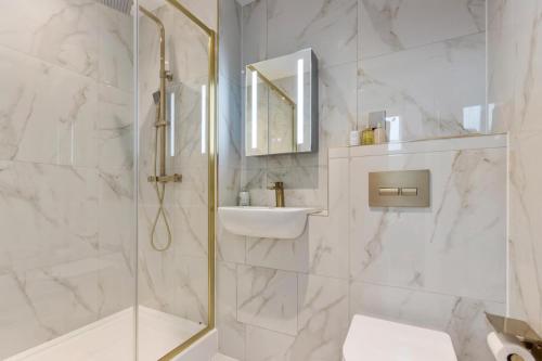 ein weißes Badezimmer mit Dusche und Waschbecken in der Unterkunft Modern 2-Bedroom Apartment, Leatherhead, Sleeps 4 in Leatherhead