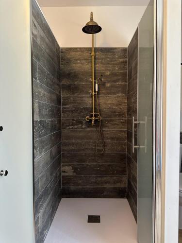 a bathroom with a shower with wooden walls at La Closerie de bourdic Uzès in Bourdic