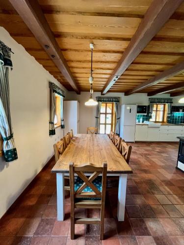 a large dining room with a wooden table and chairs at Kaproun - Studený pramen in Kunžak