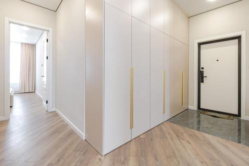 an empty hallway with white cabinets and a door at Republic Residence in Astana