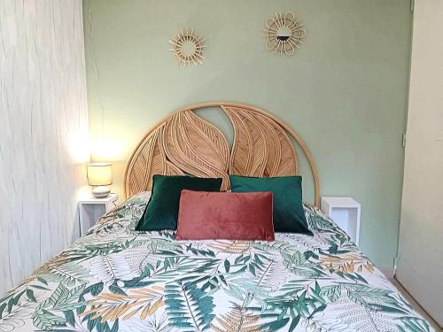 a bed with green and red pillows on it at LE COTTAGE VUE LAC-2 vélos-Village Vacances Nature de 70ha! avec piscines et animations in Léon