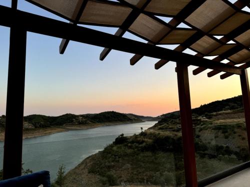 a view of a river at sunset from a house at Meria Life Stone House with Lake View in Nature in Seferihisar