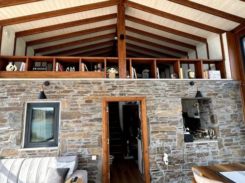 a room with a stone wall with a wooden ceiling at Meria Life Stone House with Lake View in Nature in Seferihisar