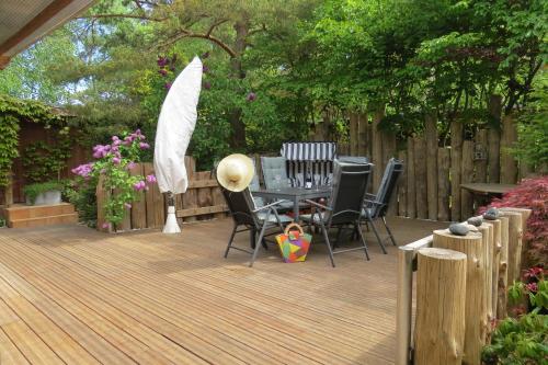 a wooden deck with chairs and a table on it at Strandhaus Möve in Wustrow