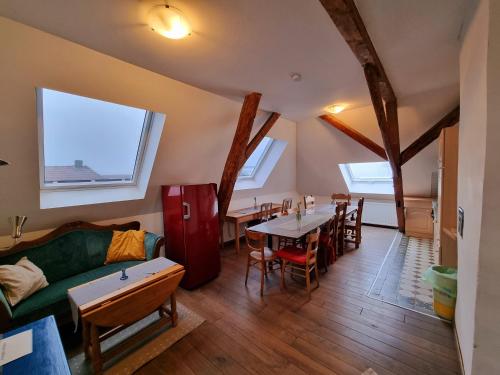 a living room with a green couch and tables and windows at Ferienwohnung über den Dächern im alten Pastorat in Kevelaer
