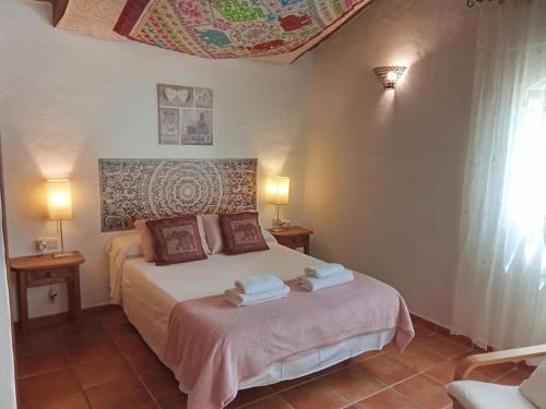 a bedroom with a bed with towels on it at Casa Rural en Málaga, donde el tiempo se detiene in Las Casillas