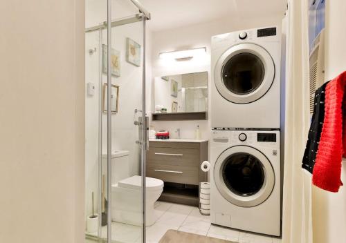 a bathroom with a washer and dryer in it at 100 METERS to METRO BEAUDRY - FULL APARTMENTS - 1 minute walk to the FAMOUS ST CATHERINE STREET - FAST WIFI - WASHER & DRYER ON SITE - Montcalm units in Montréal