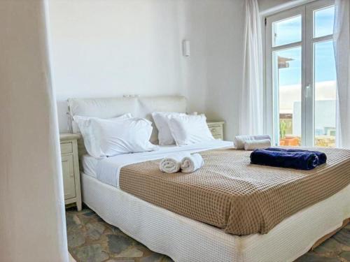 a bedroom with a bed with towels on it at White Rock Suites & Villas in Houlakia