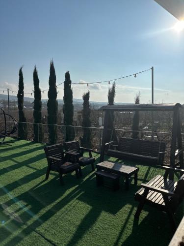 a group of benches sitting on top of a lawn at Hamsa Suite in Mas'ade