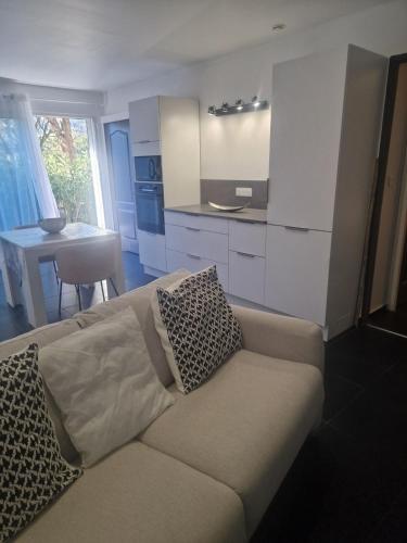 un salon avec un canapé et une cuisine dans l'établissement Appartement a 2 pas de la plage, à Rogliano