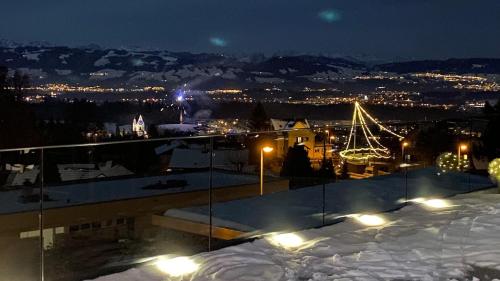 a view of a city at night with snow and lights at Modernes 3,5 Zimmer Apartment 100 m2 mit Alpenblick und 2 Terrassen in Hinwil