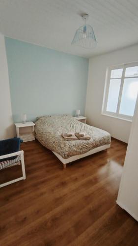 une chambre avec un lit et un parquet dans l'établissement Agréable maison avec jardin à 100m de la plage, à Berck-sur-Mer