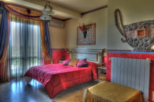 a bedroom with a bed with a red bedspread at Guest House Qui Dormì L'Etrusco in Canino