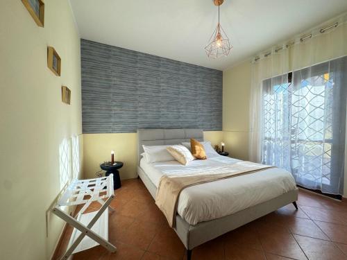 a bedroom with a bed and a large window at Casa Letizia in Ladispoli