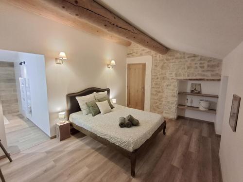 une chambre avec un lit avec deux animaux en peluche dessus dans l'établissement Domaine des Preyauts, le mas provençal, 270m, à Caromb