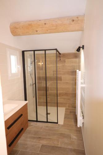 une douche avec une porte vitrée dans une salle de bain dans l'établissement Domaine des Preyauts, le mas provençal, 270m, à Caromb