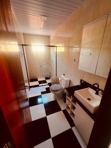 a bathroom with a black and white checkered floor at Casa na Praia de Canoas in Pontal do Paraná