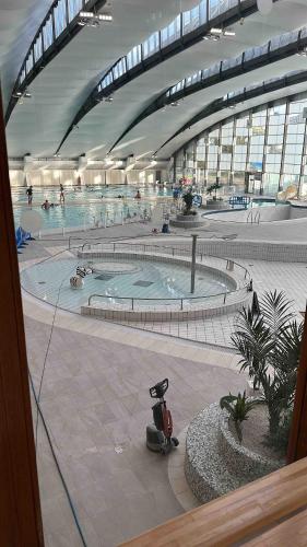une grande piscine dans un grand bâtiment dans l'établissement Cozy appartement situé à 10 min de aéroport de ROISSY CDG situé a 1 min à pied de la gare RER direction Paris centre 20min, à Louvres