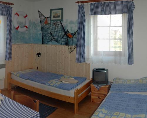 a bedroom with two beds and a tv in it at Pension U Barona Prášila in Ořech