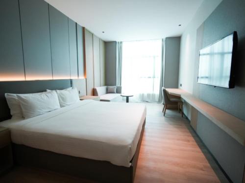 a hotel room with a bed and a television at The Inn in Bintulu