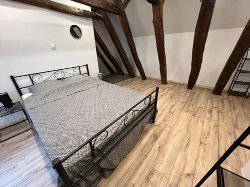 une chambre avec un lit en métal dans une pièce avec du parquet dans l'établissement Appart Montignac, à Montignac