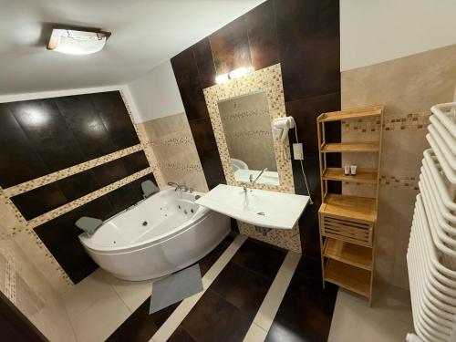 a bathroom with a tub and a sink at Magiczna Farma Hotel Obiady Mąka i Magia in Zambrów