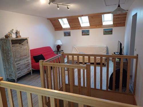 een woonkamer met een rode bank en een trap bij villa des cascades du hérisson in Bonlieu