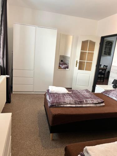 a bedroom with two beds and a large white cabinet at Penzion Mánes in Krabčice