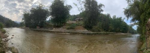 a river with trees on the side of it at Homestay Khoáng nóng Thông Nguyên in Ha Giang