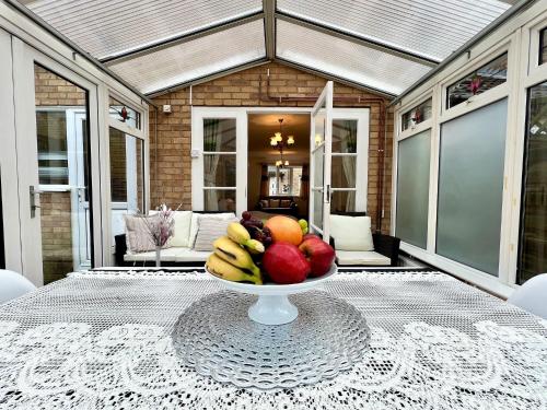 a bowl of fruit on a table on a patio at J&J stays 5 bedroom detached house in Peterborough with parking in Peterborough