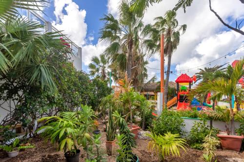 a garden with palm trees and a playground at Maho Beach House - Studio - Beach Access in Maho Reef