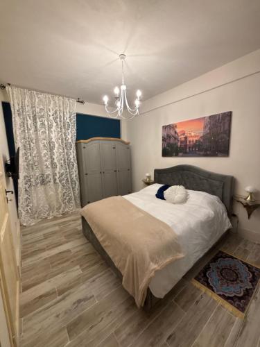 a bedroom with a bed and a chandelier at B&B Villa Brikinnia in Lentini