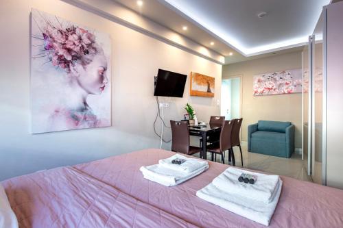 1 dormitorio con cama rosa y comedor en Central Mini Suite, en Atenas