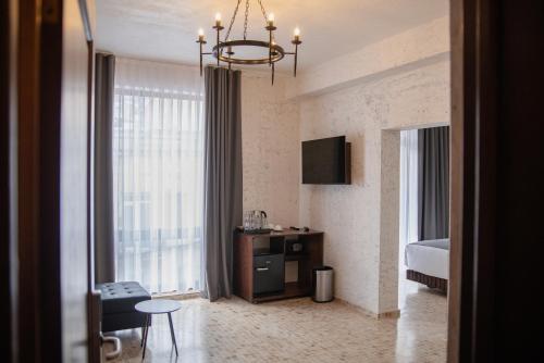 a hotel room with a bed and a chandelier at Kazma Boutique Hotel in Tbilisi City