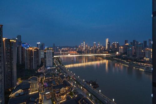 a city skyline at night with a river and buildings at ChongQing BackHome Riverview Hotel in Chongqing