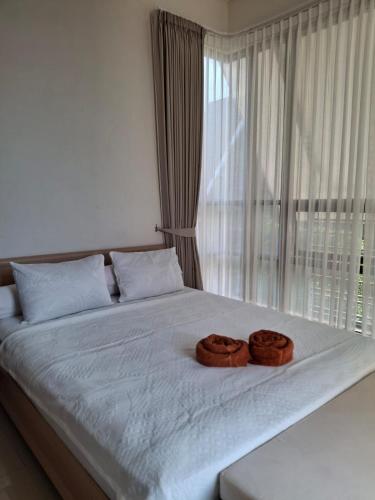 two donuts sitting on a bed in front of a window at Anagata House Batu at C8 Grand Kusuma Hill in Batu