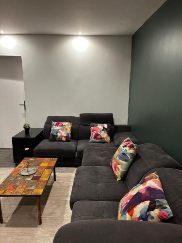 a living room with a couch and a coffee table at Havre de paix proche Paris et La Défense in Bezons