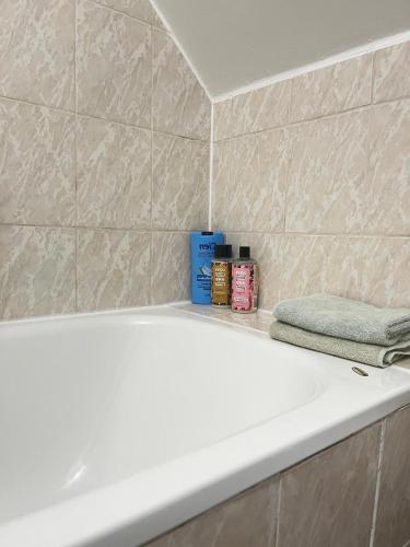 La salle de bains est pourvue d'une baignoire blanche et d'une serviette. dans l'établissement Havre de paix proche Paris et La Défense, à Bezons