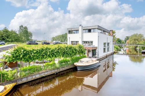a house on a river with a boat in it at Luxe Wellness Suite Zaandam - Amsterdam in Zaandam
