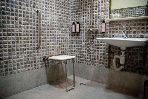 a bathroom with a sink and a stool in it at Kazma Boutique Hotel in Tbilisi City