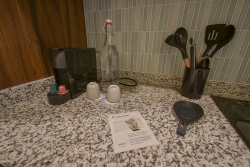a counter top with a bottle and some kitchen utensils at Expo Satelite 2750 Hotel & Suites in Guadalajara